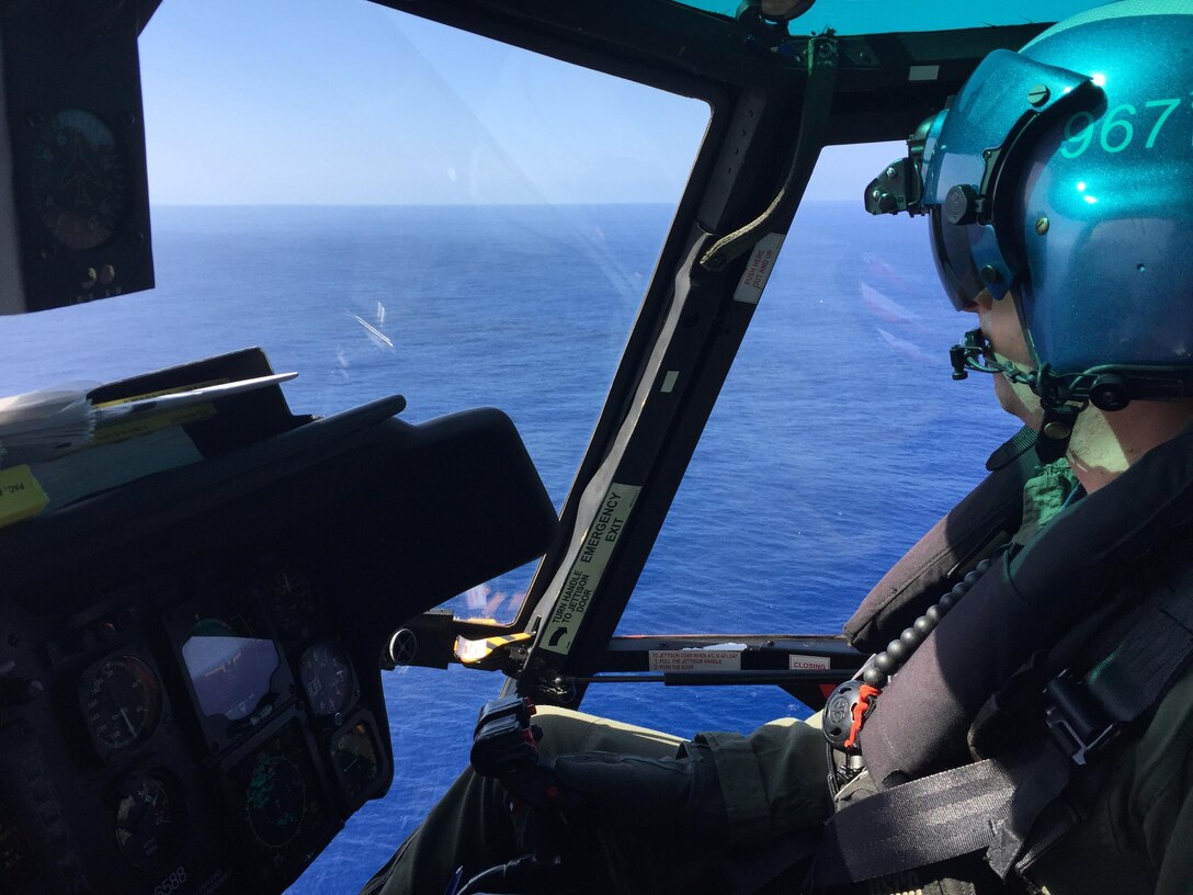 The crew of a Coast Guard MH-65 Dolphin helicopter  (CG 6608) from Air Station Barbers Point conducts a search for 12 Marine aviators off the North Shore of Oahu Jan. 17, 2016. The Dolphin crew relieved the night crew to conduct daytime searches. (U.S. Coast Guard photo by Air Station Barbers Point/Released)