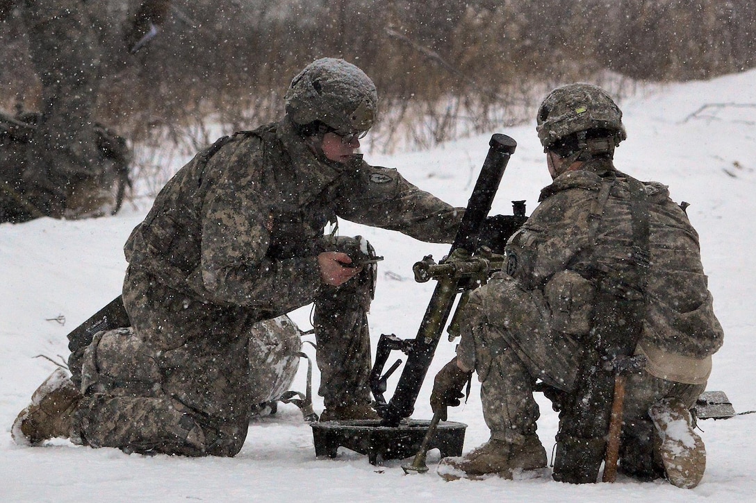 Army Spc. Connor Fleener, left, checks for the correct angle as he helps set up a 60 mm mortar before participating in a live-fire exercise on Joint Base Elmendorf-Richardson, Alaska, Jan. 12, 2016. Fleener is a mortarman assigned to Company A, 1st Battalion, 501st Infantry Regiment. U.S. Army photo by John Pennell