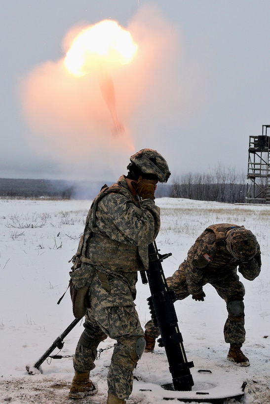 Soldiers fire a 120 mm mortar as the round exits the tube in a flash of smoke during a live-fire at exercise on Joint Base Elmendorf-Richardson, Alaska, Jan. 12, 2016. U.S. Army photo by John Pennell