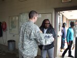 A Michigan National Guard member provides water to a resident of Flint, which is enduring a drinking-water crisis due to lead contamination of the city's water source.