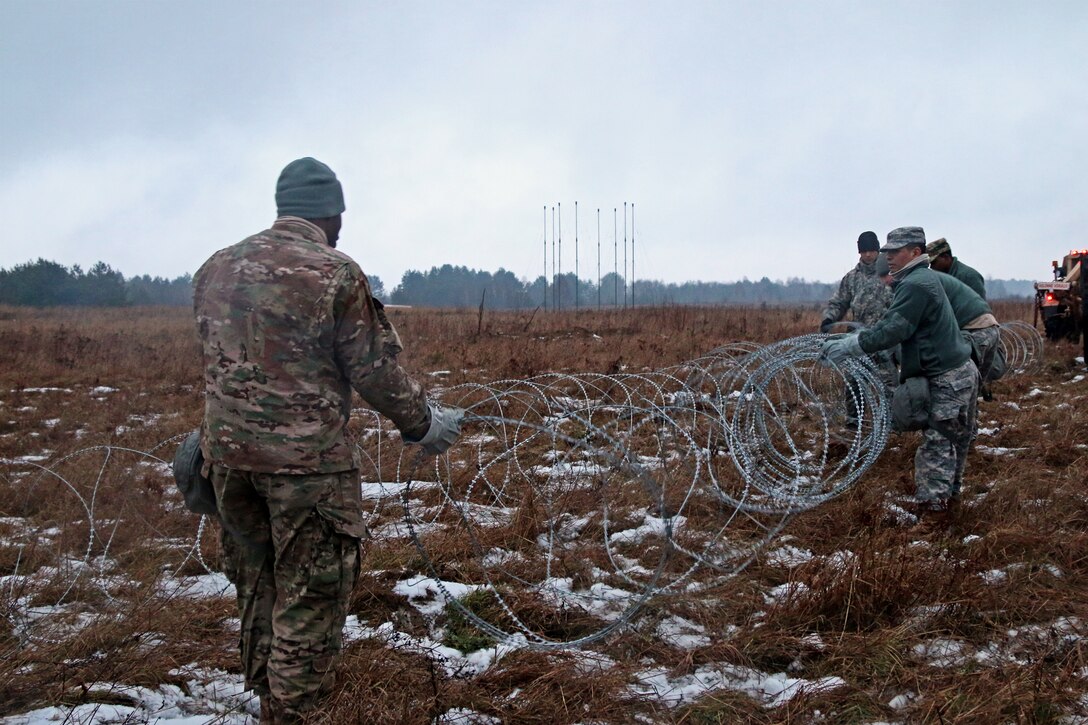 U.S. soldiers set up a three-deep barrier of concertina wire around their training area during Patriot Shock, an interoperability deployment readiness exercise in Skwierzyna, Poland, Jan. 13, 2016. The soldiers are assigned to the 5th Battalion, 7th Air Defense Artillery Brigade, and worked together with Polish and Swedish forces to validate the unit’s readiness and rapid deployment capabilities using M901 Patriot Launching Stations. U.S. Army photo by Sgt. Paige Behringer