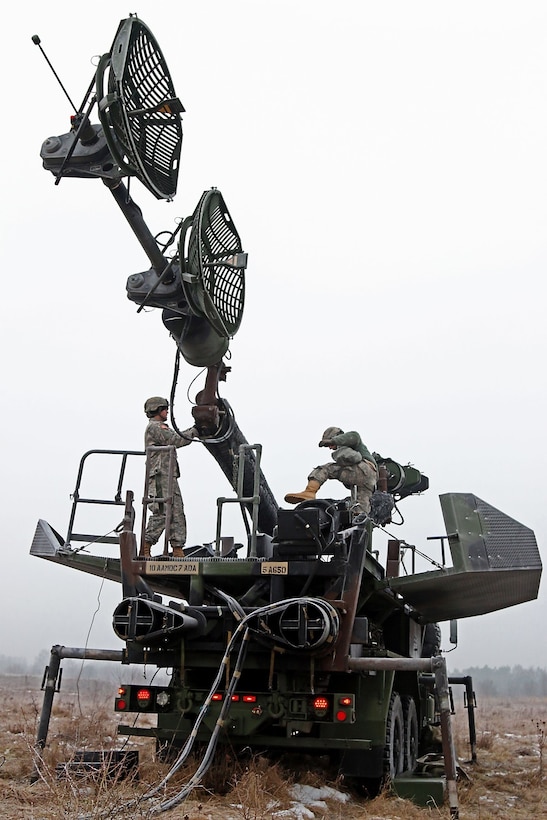U.S. Army Pfcs. Jeremy Farnworth, left, and Bo Latner collapse the antenna mast group during Patriot Shock, an interoperability deployment readiness exercise in Skwierzyna, Poland, Jan. 15, 2016. U.S. Army photo by Sgt. Paige Behringer