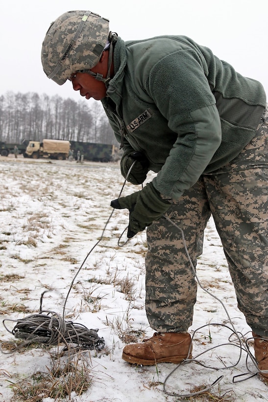 U.S. Army Spc. Stacey Rice unravels wires for the antenna mass group her team is setting up during Panther Assurance, part of Patriot Shock, an interoperability deployment readiness exercise in Skwierzyna, Poland, Jan. 15, 2016. U.S. Army photo by Sgt. Paige Behringer