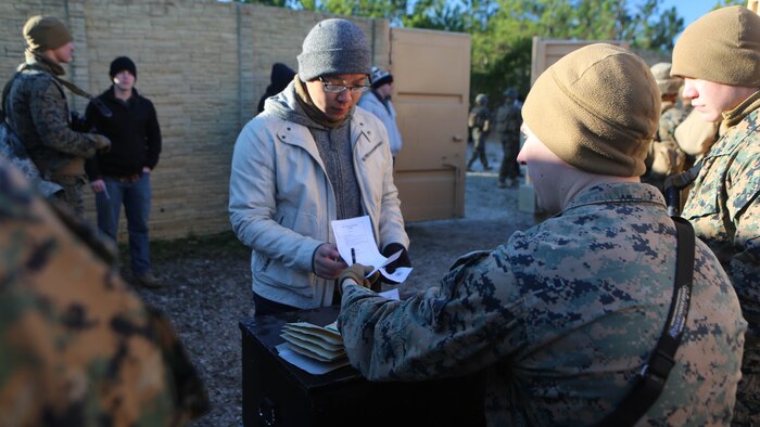 Lance Cpl. Jordan Martin, a rifleman with 2nd Battalion, 2nd Marine Regiment, evaluates and records a refugee role player’s identification paperwork during a noncombatant evacuation training operation  at Marine Corps Base Camp Lejeune, North Carolina, Jan. 14, 2016. The Marines successfully processed 28 refugee role players through a notional forward operating base. The exercise was part of the unit’s training in preparation for an upcoming deployment to Okinawa, Japan. 