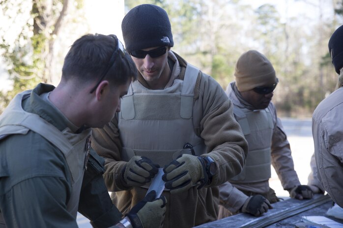 Explosive Ordinance Disposal technicians with EOD Company, 8th Engineer Support Battalion, wrap tape around detonation cord during a breaching course at Camp Lejeune, N.C., Jan. 14, 2016. Marines participate in this course every six months to be certified breachers. (U.S. Marine Corps photo by Lance Cpl. Samuel Guerra/Released)