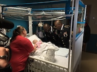 Master Sgt. Troy Roberson and Sgt. 1st Class Joseph Bush from the 11th Theater Aviation Command (TAC), comfort an infant at Kosair Children’s Hospital in Louisville, Ky., Jan. 9. Soldiers from the 11th TAC volunteered their time to distribute toys to hospitalized children. The toys were donated by soldiers, family members and friend of the 11th TAC. The 11th TAC is the only aviation command in the U.S. Army Reserve. (U.S. Army photo by Capt. Matthew Roman, 11th Theater Aviation Command Public Affairs Officer)