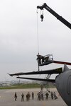 U.S. Air Force Airmen of the 18th Aircraft Maintenance Squadron and a U.S. Navy Seabees of Naval Mobile Construction Battalion 3 use a Link Belt 40-ton crane to fold down the tail fin of a KC-135 Stratotanker Jan. 14, 2016, at Kadena Air Base, Japan. Airmen and Seabees coordinated a joint operation to replace a worn out rudder on the tail section of the aircraft. 