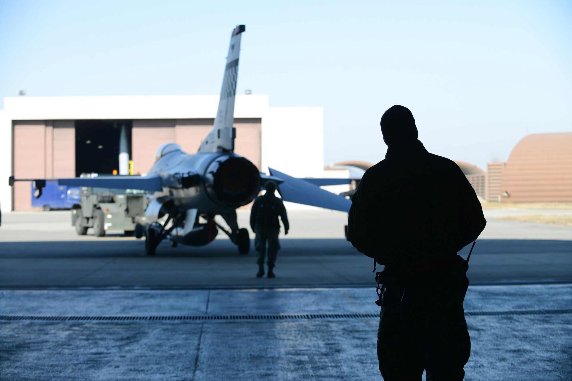 Staff Sgt. Matthew Nauta, 36th Aircraft Maintenance Unit crew chief, directs an F-16 Fighting Falcon into a phase hangar for post-flight phase inspections at Osan Air Base, Republic of Korea, Jan. 12, 2016. Crew chiefs work inside hangars or on the flightline getting the the F-16s inspected and maintained. (U.S. Air Force photo by Airman 1st Class Dillian Bamman/Released)