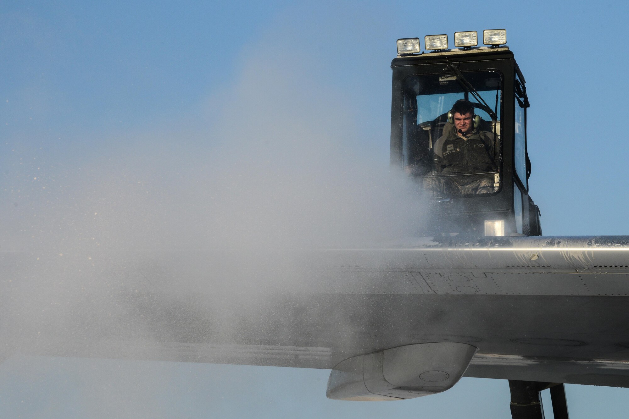 Senior Airman Christopher Gonzalez, 51st Maintenance Squadron transient alert specialist, uses an aircraft de-icer on a government chartered aircraft after a large amount of snowfall at Osan Air Base, Republic of Korea, Jan. 14, 2016. Gonzalez sprayed the aircraft with de-icing fluid helps melt the snow and ice to keep the aircraft from weight complications during flight. (U.S. Air Force photo by Airman 1st Class Dillian Bamman/Released)