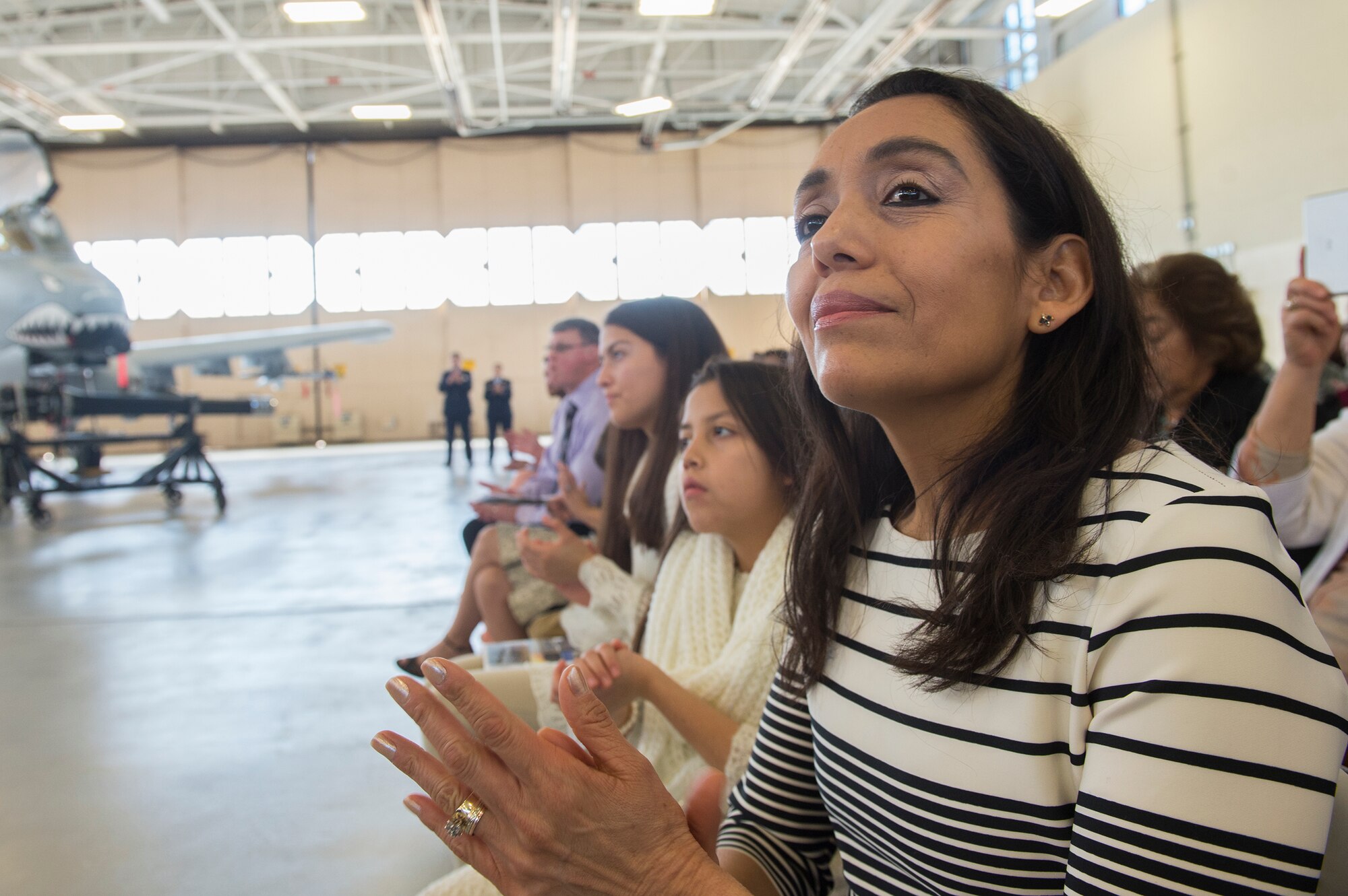 Beatriz Castillo, wife of U.S. Air Force Chief Master Sgt. Guillermo Castillo, 23d Maintenance Group wing weapons manager, claps during her husband’s retirement ceremony, Jan. 15, 2016, at Moody Air Force Base, Ga. Now that Castillo is retired, he plans to use his spare time to reimburse his wife and four children for all of the sacrifices they made for his career. (U.S. Air Force photo by Senior Airman Ceaira Tinsley/Released)