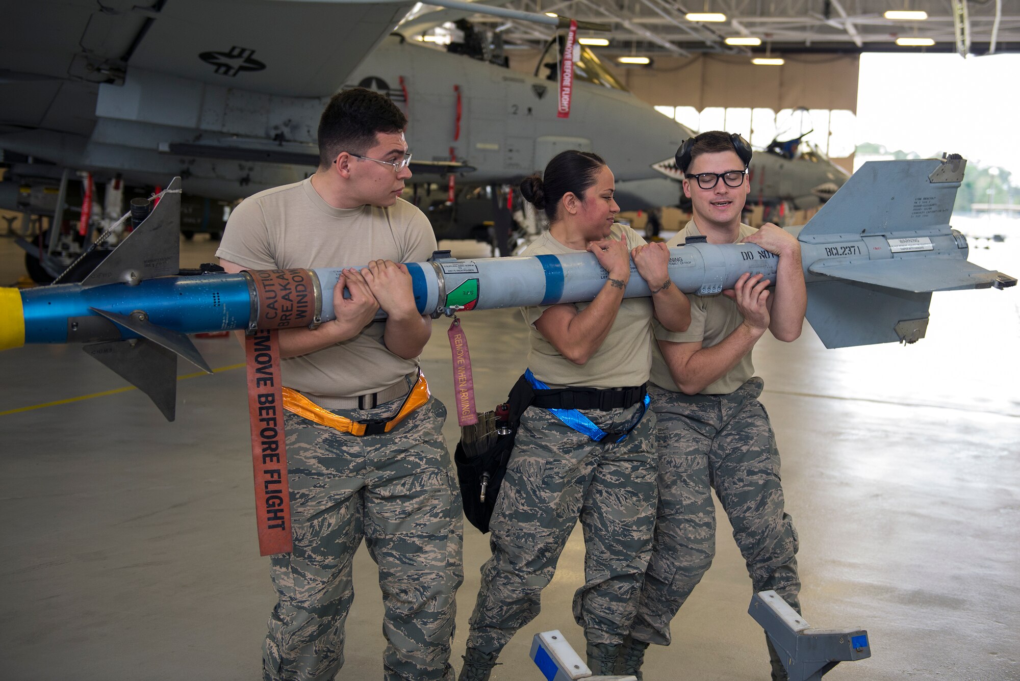 Weapons load crew members of the 74th Aircraft Maintenance Unit lift an AIM-9 Sidewinder missile during the quarterly weapons load competition, Jan. 15, 2016, at Moody Air Force Base, Ga. The competing load crews also loaded MK-82 high and low drag bombs while ensuring that munitions were safe, serviceable and were properly configured. (U.S. Air Force photo by Airman 1st Class Greg Nash/Released) 