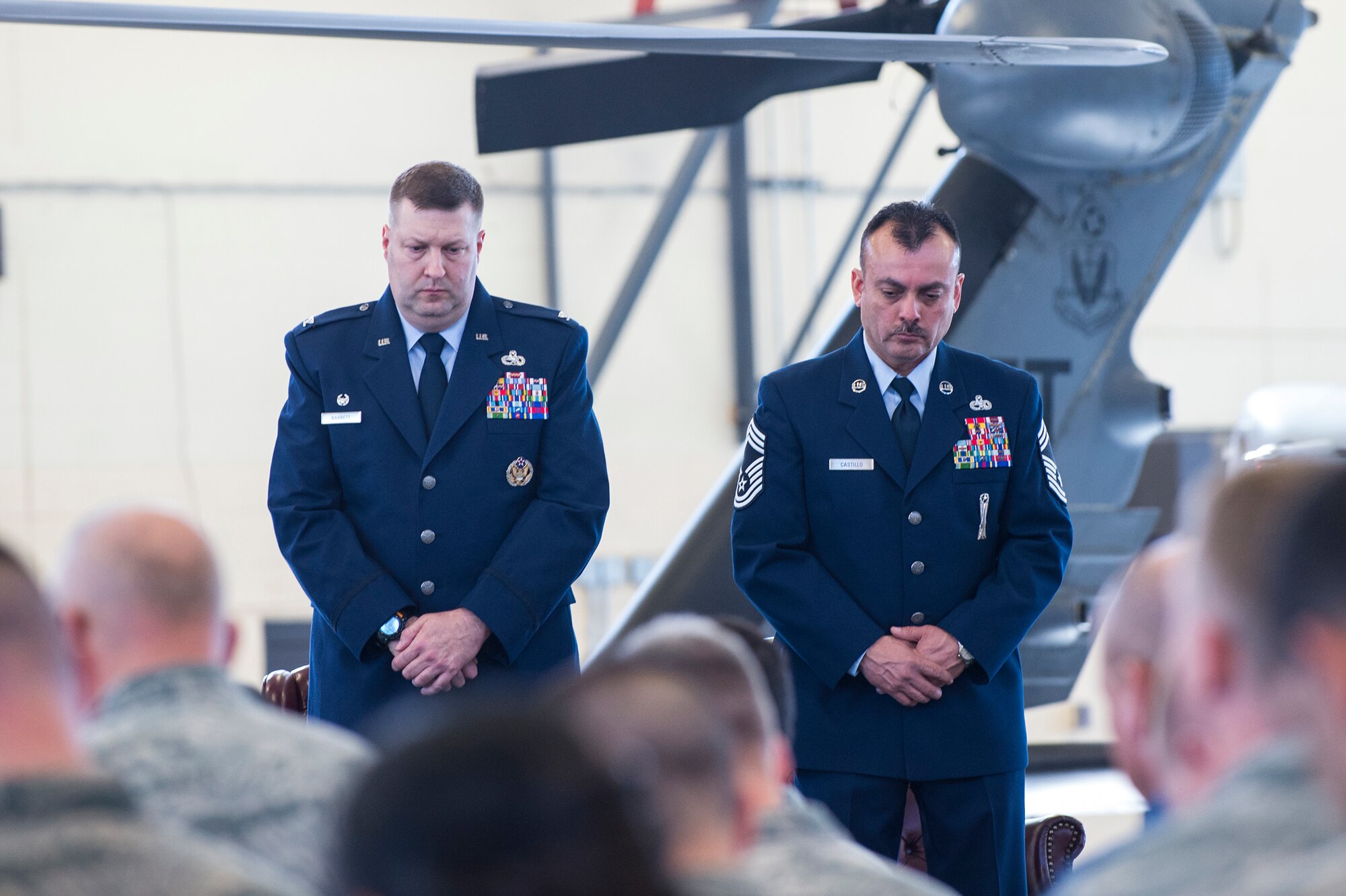 U.S. Air Force Col. Shane Barrett, 23d Maintenance Group commander and Chief Master Sgt. Guillermo Castillo, 23d MXG wing weapons manager, bow their head for a moment of silence during Castillo’s retirement ceremony, Jan. 15, 2016, at Moody Air Force Base, Ga. Castillo retired after serving on active duty for 30 years. (U.S. Air Force photo by Senior Airman Ceaira Tinsley/Released)