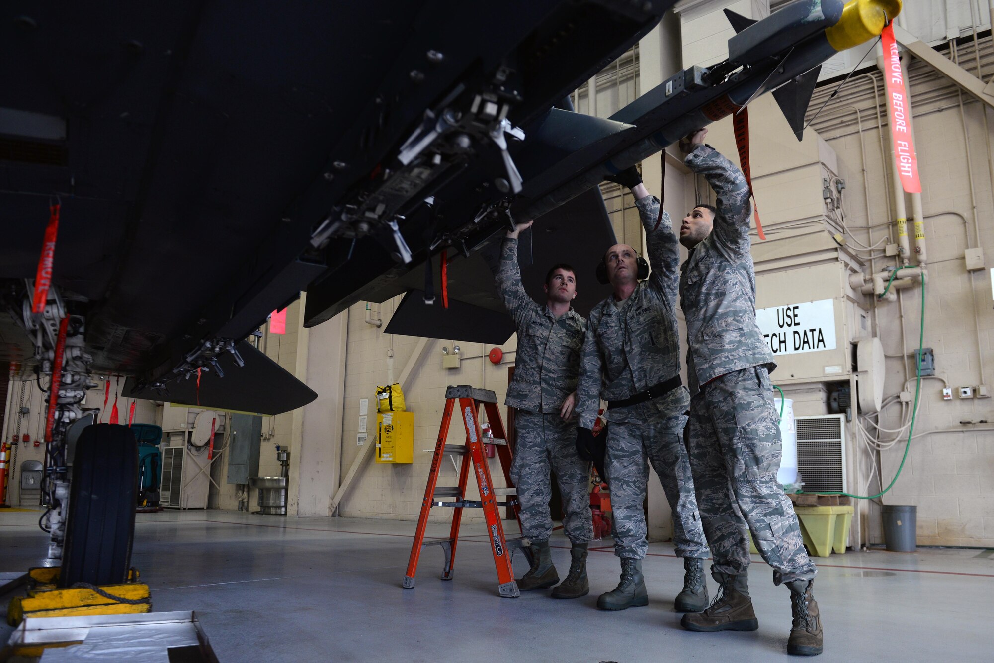 From left, Senior Airman Aaron Miller, Tech Sgt. Michael Wallace and Senior Airman Jordan Wilson, 4th Aircraft Maintenance Squadron weapons load technicians, install a munition on an F-15E Strike Eagle during the Load Crew of the Year competition, Jan. 15, 2016, at Seymour Johnson Air Force Base, North Carolina. Each aircraft maintenance unit fielded teams of three Airmen who participated in the competition for training, morale and bragging rights. (U.S. Air Force photo/Senior Airman John Nieves Camacho)