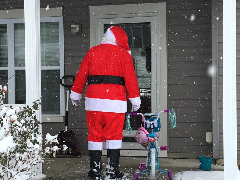 Santa prepare to deliver a bike to a Team Offutt child on Christmas Eve. Santa, Rising View and Papillion Sanitation Department have delivered more than a hundred bikes to children with deployed caregivers over the last two years. (Courtesy photo)