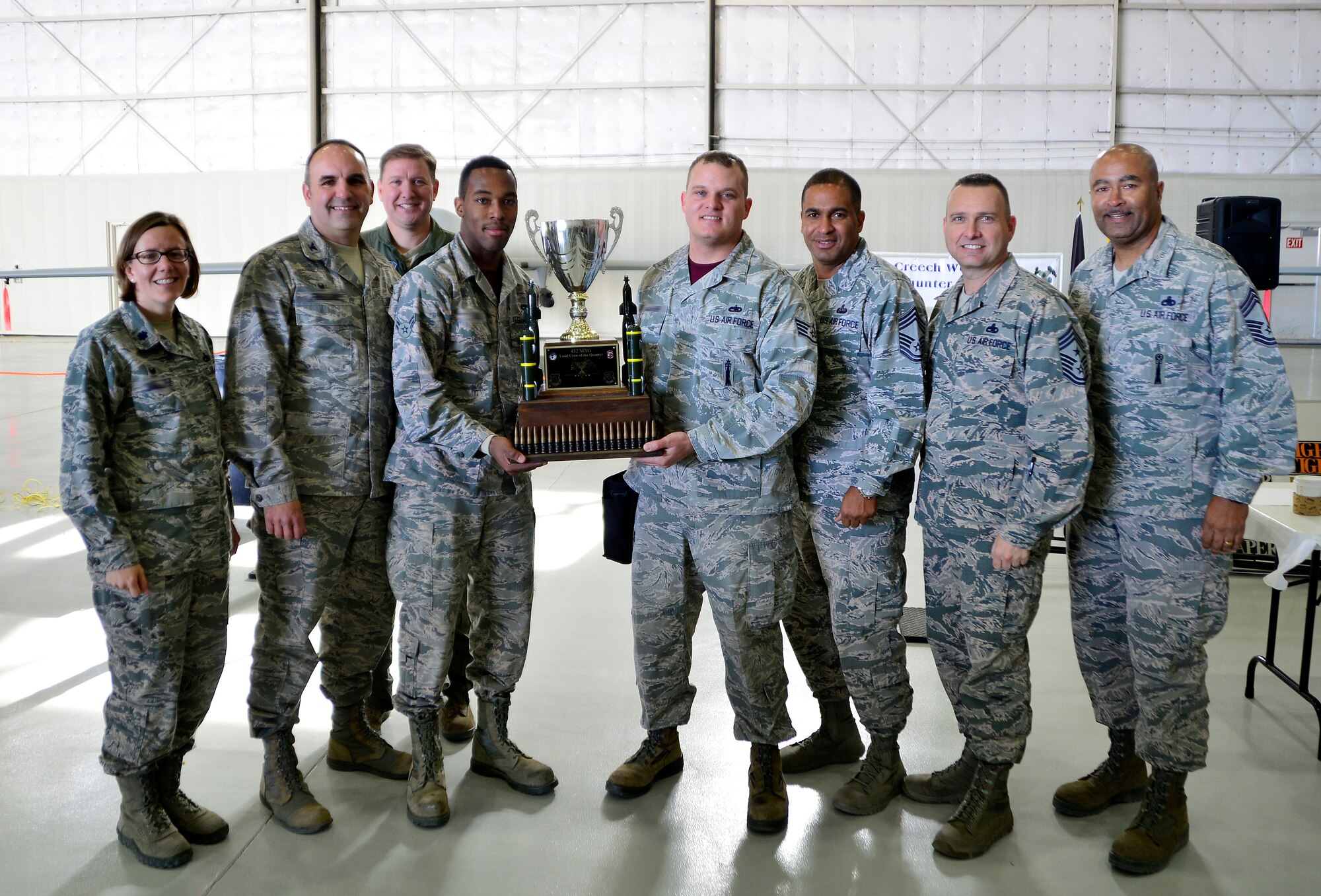 The Reaper Aircraft Maintenance Unit poses with 432nd Wing leadership after winning the fourth quarter Load Crew of the Quarter competition Jan. 14, 2016, at Creech Air Force Base, Nevada. The members of the Reaper AMU are now eligible to compete in the upcoming Load Crew of the Year competition.  (U.S. Air Force photo by Senior Airman Christian Clausen/Released)