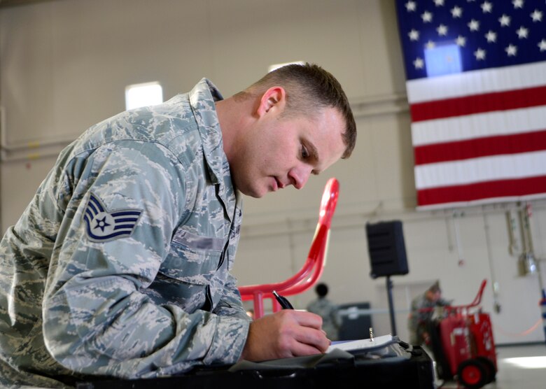 Staff Sgt. Charlie, 432nd Aircraft Maintenance Squadron weapons load crew chief finishes a checklist during the fourth quarter Load Crew of the Quarter competition Jan. 14, 2016, at Creech Air Force Base, Nevada. Charlie, along with his teammate Airman 1st Class Quantavious, 432nd AMXS weapons load crew member, finished loading two Hellfire missiles in under three and a half minutes.  (U.S. Air Force photo by Senior Airman Christian Clausen/Released)