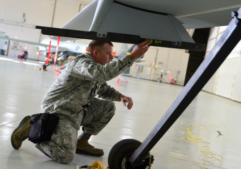Staff Sgt. Charlie, 432nd Aircraft Maintenance Squadron weapons load crew chief inspects a weapons pylon during the fourth quarter Load Crew of the Quarter competition Jan. 14, 2016, at Creech Air Force Base, Nevada. Charlie, along with his teammate Airman 1st Class Quantavious, 432nd AMXS weapons load crew member, finished loading two Hellfire missiles in under three and a half minutes.  (U.S. Air Force photo by Senior Airman Christian Clausen/Released)