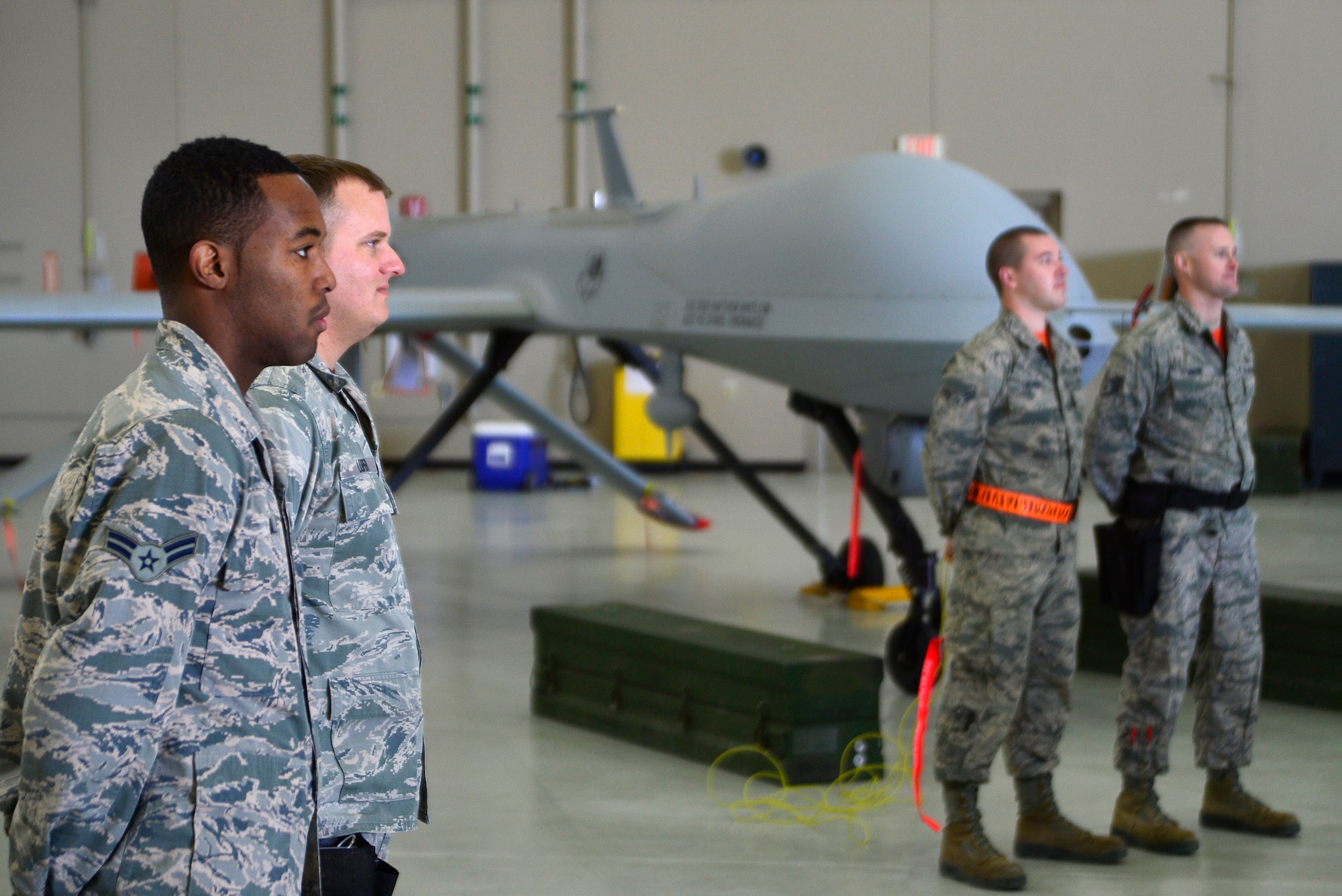 The Reaper Aircraft Maintenance Unit weapons load crew team, left, and Tiger AMU weapons load crew team, right, prepare for the fourth quarter Load Crew of the Quarter competition Jan. 14, 2016, at Creech Air Force Base, Nevada. The teams were charged with loading two Hellfire missiles onto an MQ-1 Predator in under five minutes while committing as few discrepancies as possible. (U.S. Air Force photo by Senior Airman Christian Clausen/Released)