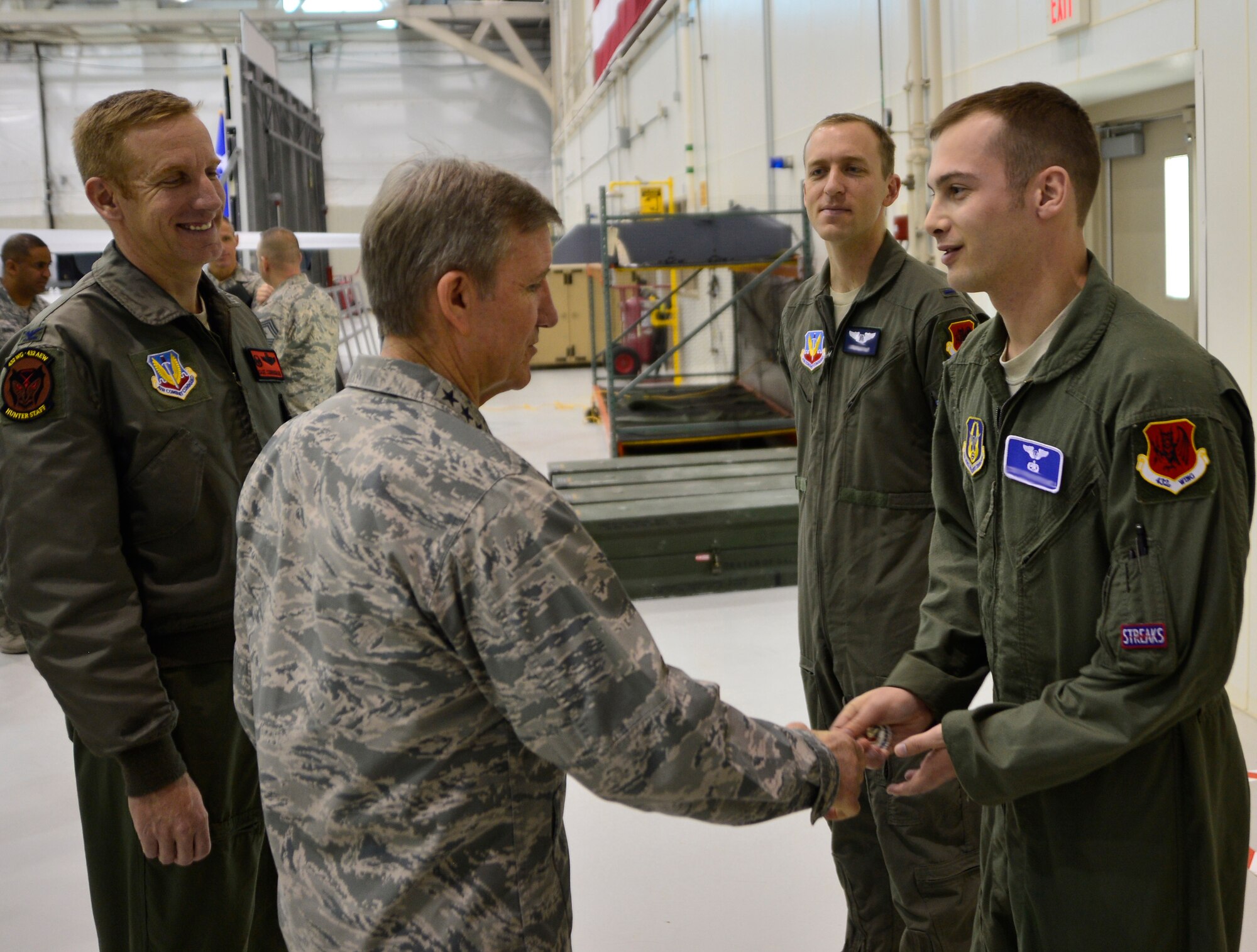 Gen. Hawk Carlisle, commander of Air Combat Command, coins Tech. Sgt. Chad, 91st Attack Squadron sensor operator Jan. 14, 2016, during his visit to Creech Air Force Base, Nevada. Carlisle coined five superior performers from around the wing for their outstanding contributions to the remotely piloted enterprise. (U.S. Air Force photo by Senior Airman Christian Clausen/Released)  