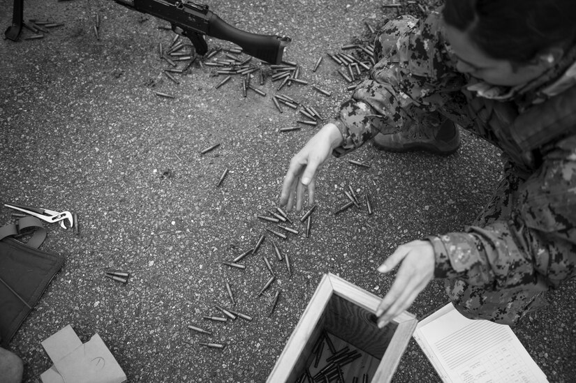 A sailor collects empty shell casings during a weapons sustainment training Jan. 9, 2016 at Joint Base Charleston, S.C .The two day, semi-annual training event was hosted by the Coastal Riverine Squadron 10 Bravo Company, a Navy Reserve team stationed at Joint Base Charleston – Weapons Station. The participants were required to show proficiency and familiarization with the M240B machine gun. (U.S Air Force Photo/Staff Sgt. Jared Trimarchi)