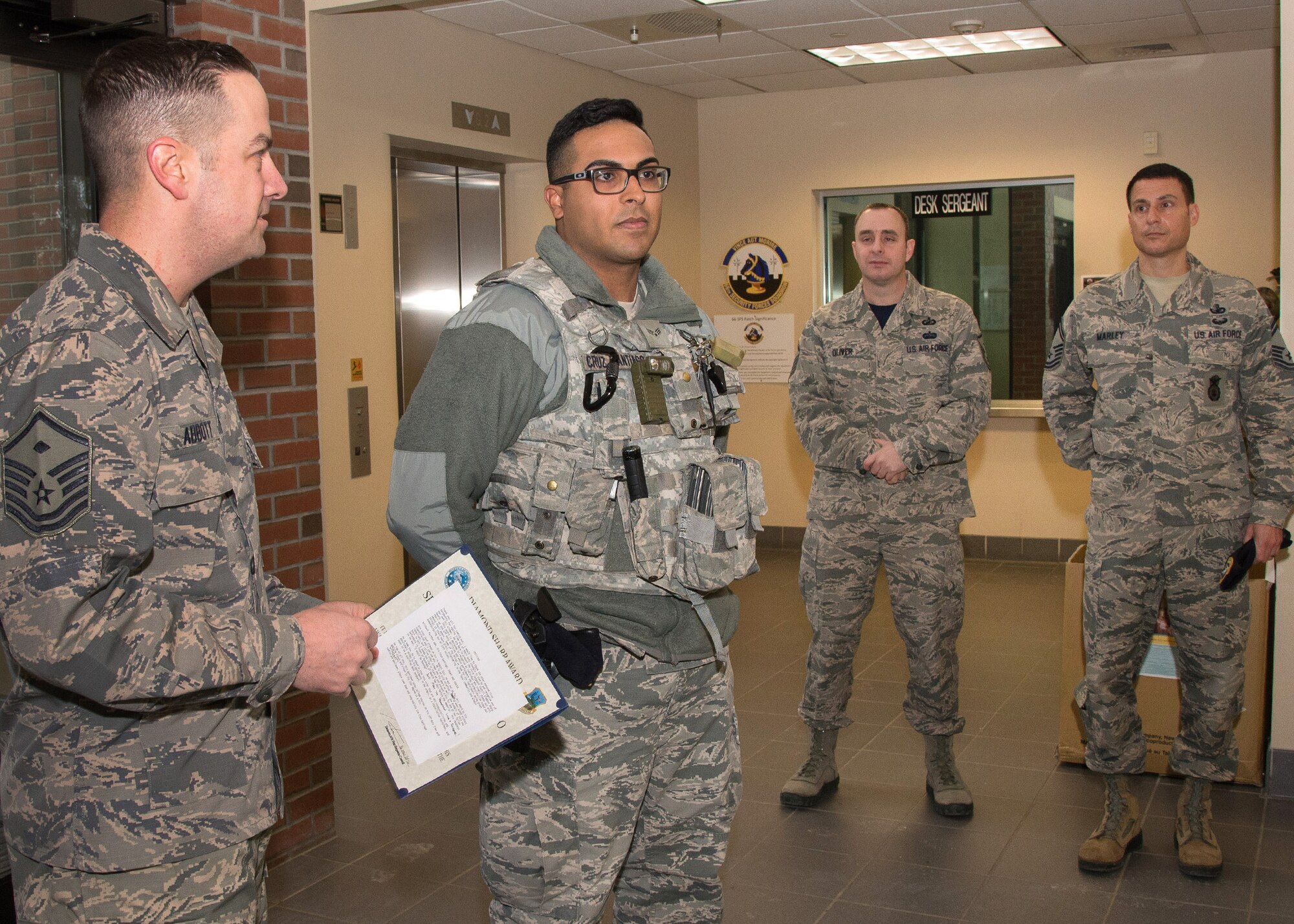 Senior Airman Wilyaveh Cruz-Santiago, 66th Security Forces Squadron patrolman, is presented the Diamond Sharp Award by Master Sgt. Richard Abbott, 66th Security Forces Squadron first sergeant, during a presentation on base Jan. 15. The Diamond Sharp program, run by the First Sergeant Council, recognizes Airmen in the grades of airman basic through technical sergeant. (U.S. Air Force photo by Mark Herlihy)