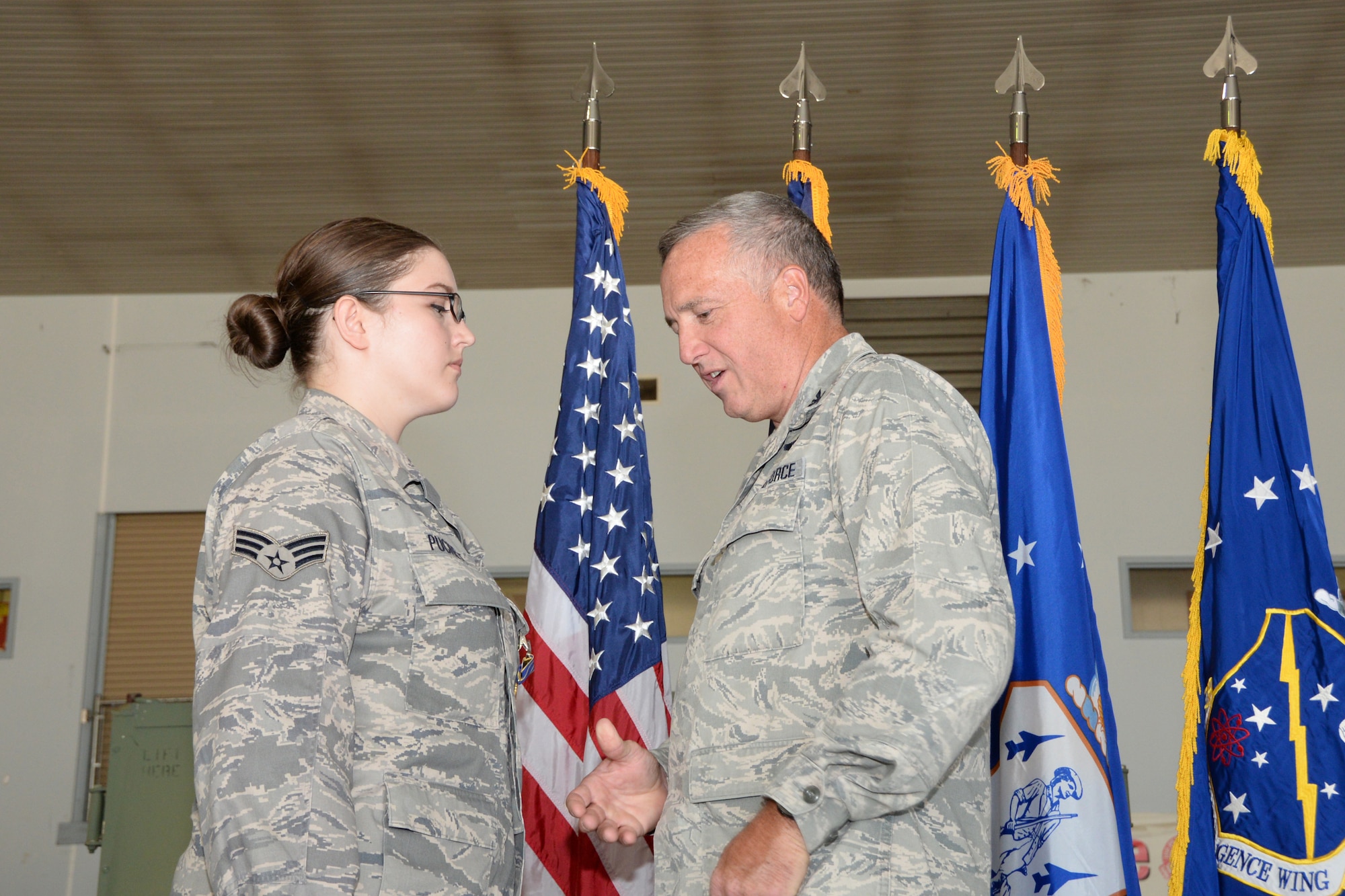 U.S. Air Force Colonel L. Kip Clark, right, the commander of the 181st Intelligence Wing presents Senior Airman Leah Puckett, left, with the Indiana Distinguished Service Cross, November 8, 2015. (U.S. Air National Guard photo by Airman 1st Class Lonnie Wiram)