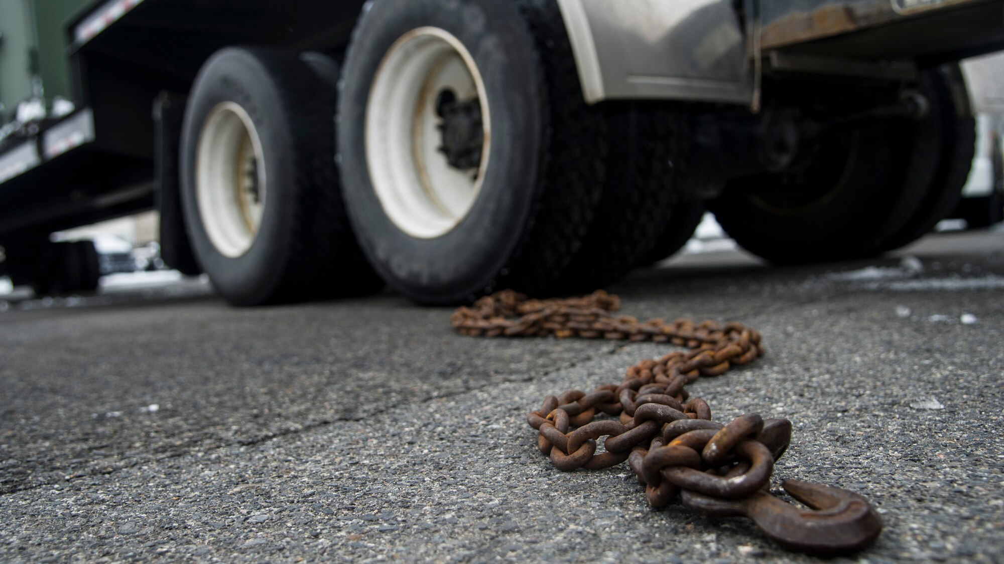 One of the many jobs that vehicle ops conducts is the transportation of equipment. This includes personal gear, aircraft parts and cad bins. In order to attach the cad bins and other equipment to a flatbed trailer they use iron chain. (U.S. Air Force photo/Airman 1st Class Sean Campbell)