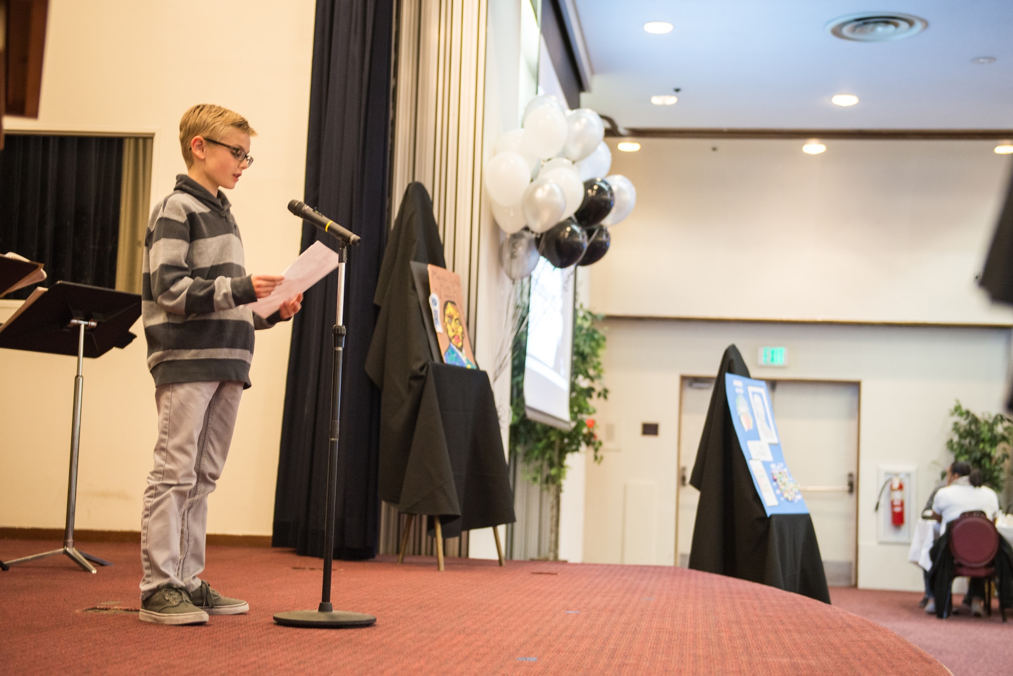 Mason, son of Col. Douglas DeLaMater, 374th Airlift Wing commander, gives his speech at the Dr. Martin Luther King Jr. Luncheon at Yokota Air Base, Japan, Jan. 14, 2015. Yokota Middle School students participated in a MLK Jr. speech writing contest, the winner gave their speech at the luncheon. (U.S. Air Force photo by Staff Sgt. Michael Smith/Released)