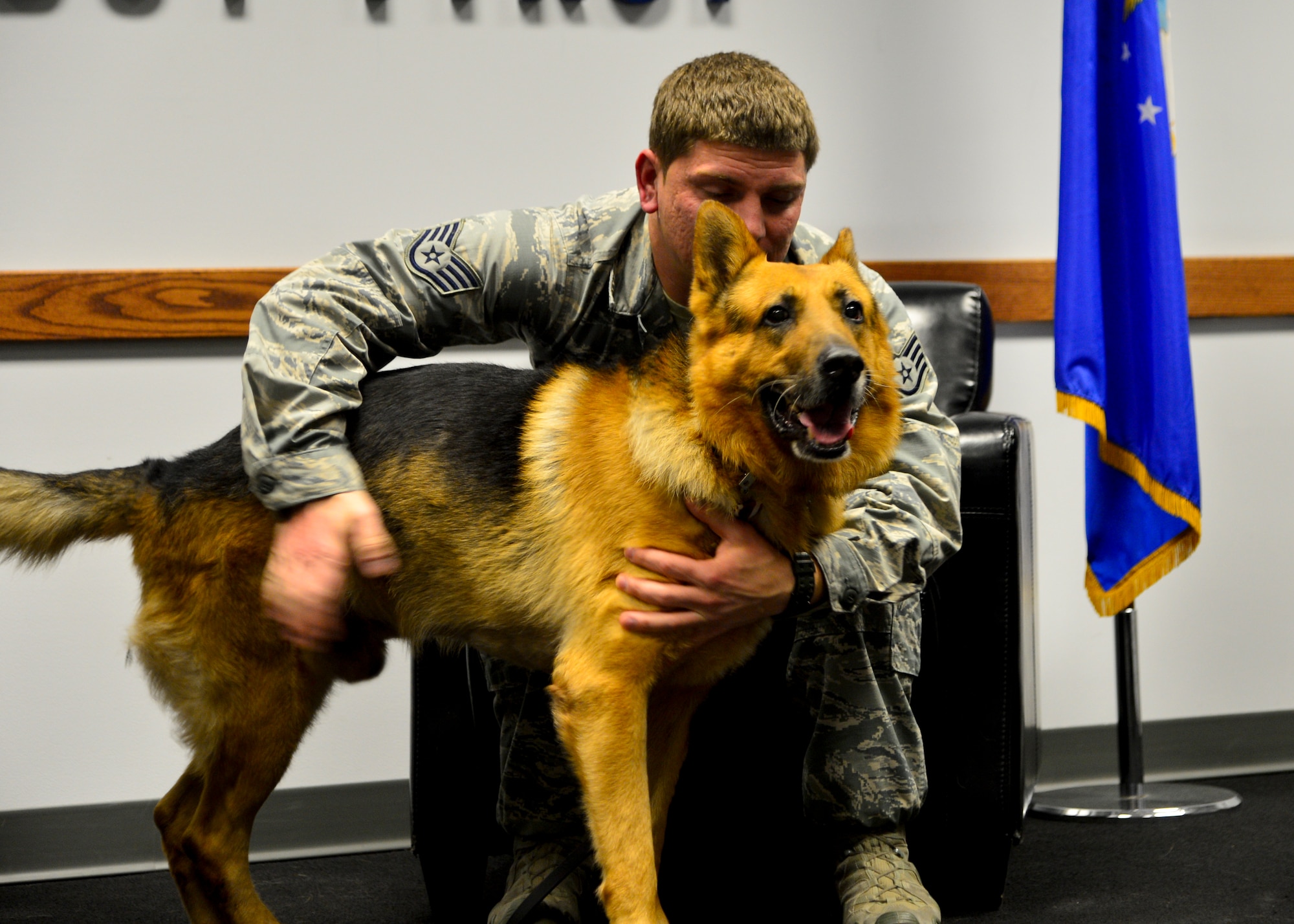 Staff Sgt. Jason Spangenberg, 436th Security Forces Squadron military working dog trainer, pets MWD Rico/M137 following Rico’s retirement ceremony Jan. 15, 2016, at Dover Air Force Base, Del. Spangenberg and Rico earned the Army Combat Infantry Badge, Air Force Combat Action Badge and a Bronze Star while deployed to Village Stability Platform Tash Guzar, Afghanistan, in support of Operation Enduring Freedom. (U.S. Air Force photo/Senior Airman William Johnson)