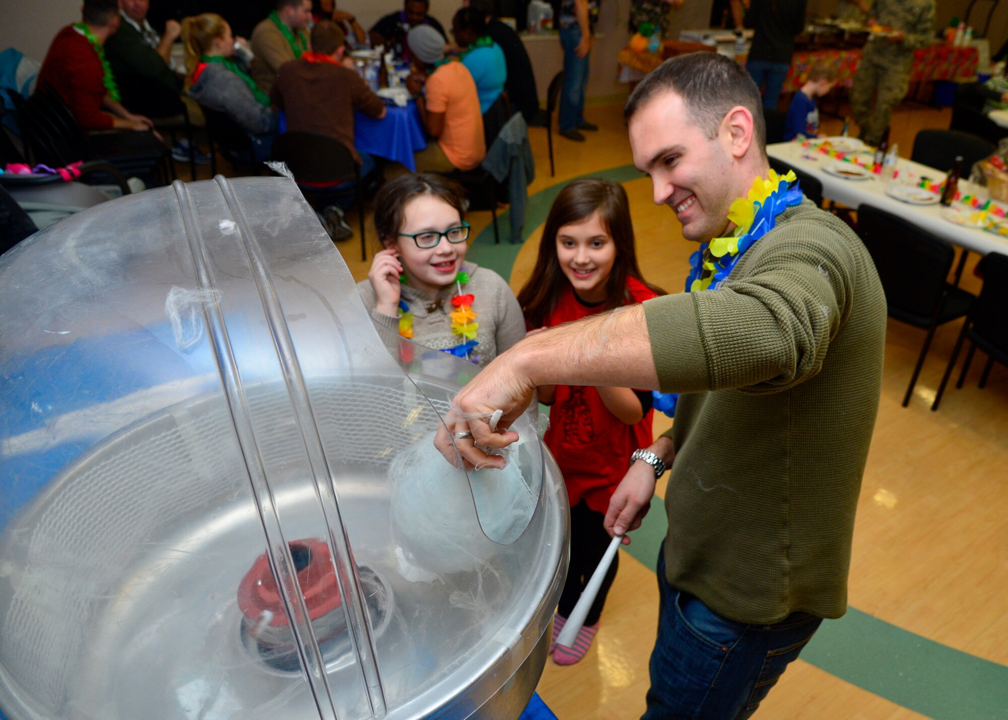 First Lt. Isaac Scherrer, 3d Airlift Squadron pilot collects cotton candy to serve during a Deployed Families and Spouses Dinner Jan. 14, 2016, at the Youth Center on Dover Air Force Base, Del. The Airman and Family Readiness center and the 436th Operations Group hosted the dinner to allow children of deployed members to enjoy a night of free food and games. (U.S. Air Force photo/Senior Airman William Johnson)