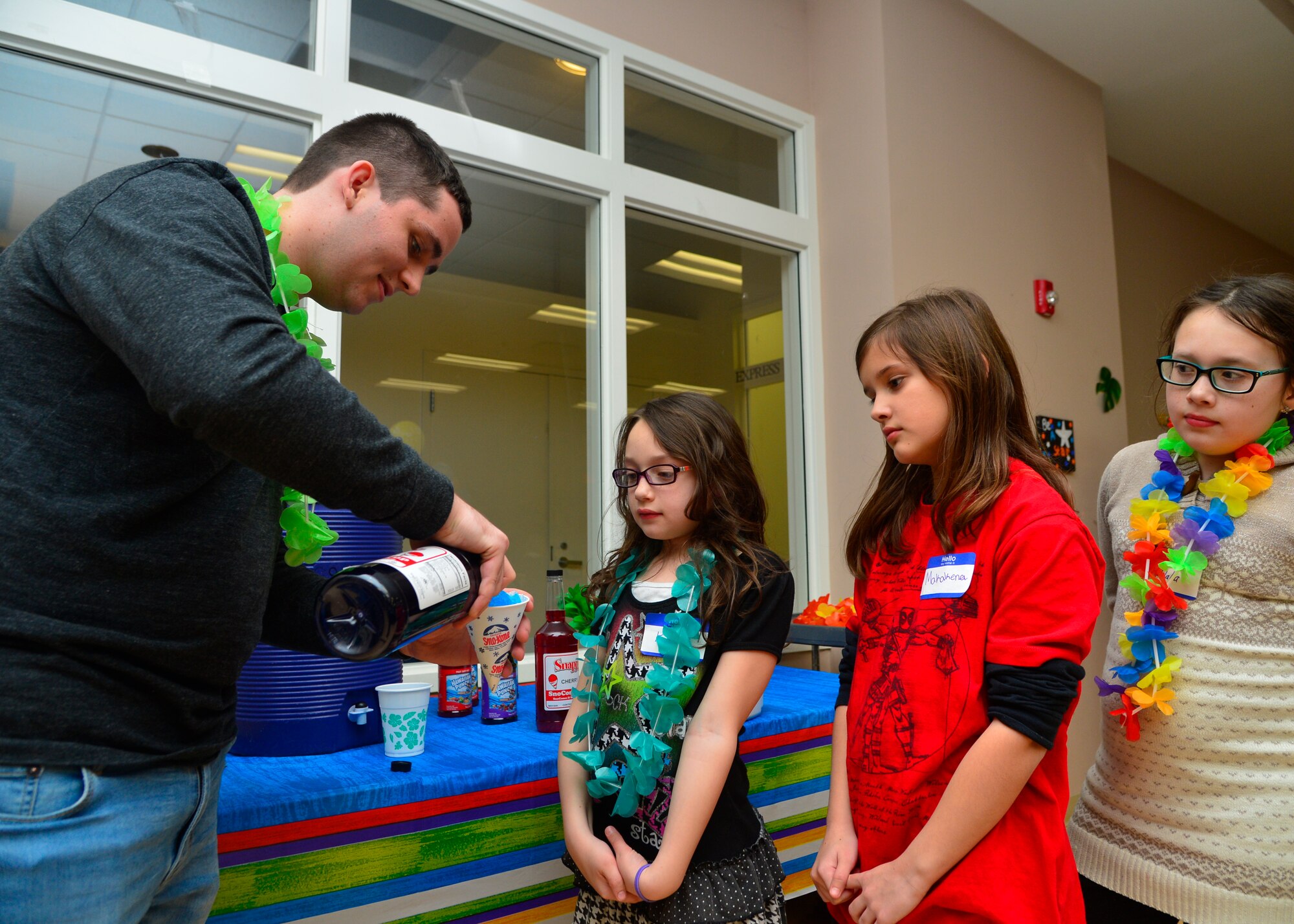 Senior Airman Matthew Walters, 3d Airlift Squadron loadmaster, makes a snow cone for Mackenzie Kohne, daughter of Tech. Sgt. Michael Kohne, 436th Security Forces Squadron, during a Deployed Families and Spouses Dinner Jan. 14, 2016, at the Youth Center on Dover Air Force Base, Del. Children of deployed Team Dover members enjoyed a pizza and barbeque style dinner with desserts including cotton candy, cookies and cake. (U.S. Air Force photo/Senior Airman William Johnson)