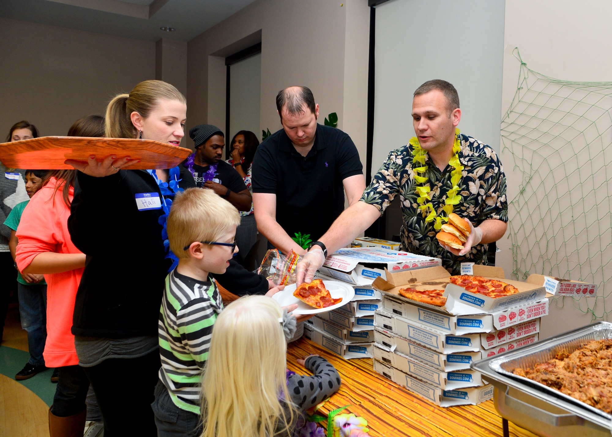 Lt. Col. Aaron Oelrich, 436th Operations Support Squadron commander, serves slices of pizza to Ryder and Roxy Swoape, children of Capt. Brent Swoape, 3d Airlift Squadron pilot, during the Deployed Families and Spouses Dinner Jan. 14, 2016, at the Youth Center on Dover Air Force Base, Del. The Airman and Family Readiness Center and the 436th Operations Group hosted the dinner to allow spouses and families of deployed members the opportunity to enjoy a meal, play games and receive information from base support agencies. (U.S. Air Force photo/Senior Airman William Johnson)