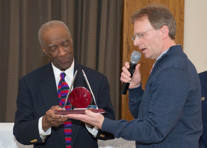 Lance Beebe, right, Dr. Martin Luther King, Jr. observance officer in charge, presents retired Lt. Col. Enoch Woodhouse, III with a gift following his presentation as the guest speaker during the remembrance observance at the base chapel Jan. 15. Woodhouse first joined the U.S. Army Air Corps and completed Officers Candidate School in 1946, at the age of 19. Woodhouse served as finance officer for the Tuskegee Airmen 477th Bombardment Group at Lockbourne Air Force Base, Ohio. When discharged from active duty in 1949, he joined the Air Force Reserves. While a reservist, Woodhouse attended Yale University and Boston University Law School and was assigned to the JAG office in 1956 at Hanscom. (U.S. Air Force photo by Jerry Saslav)