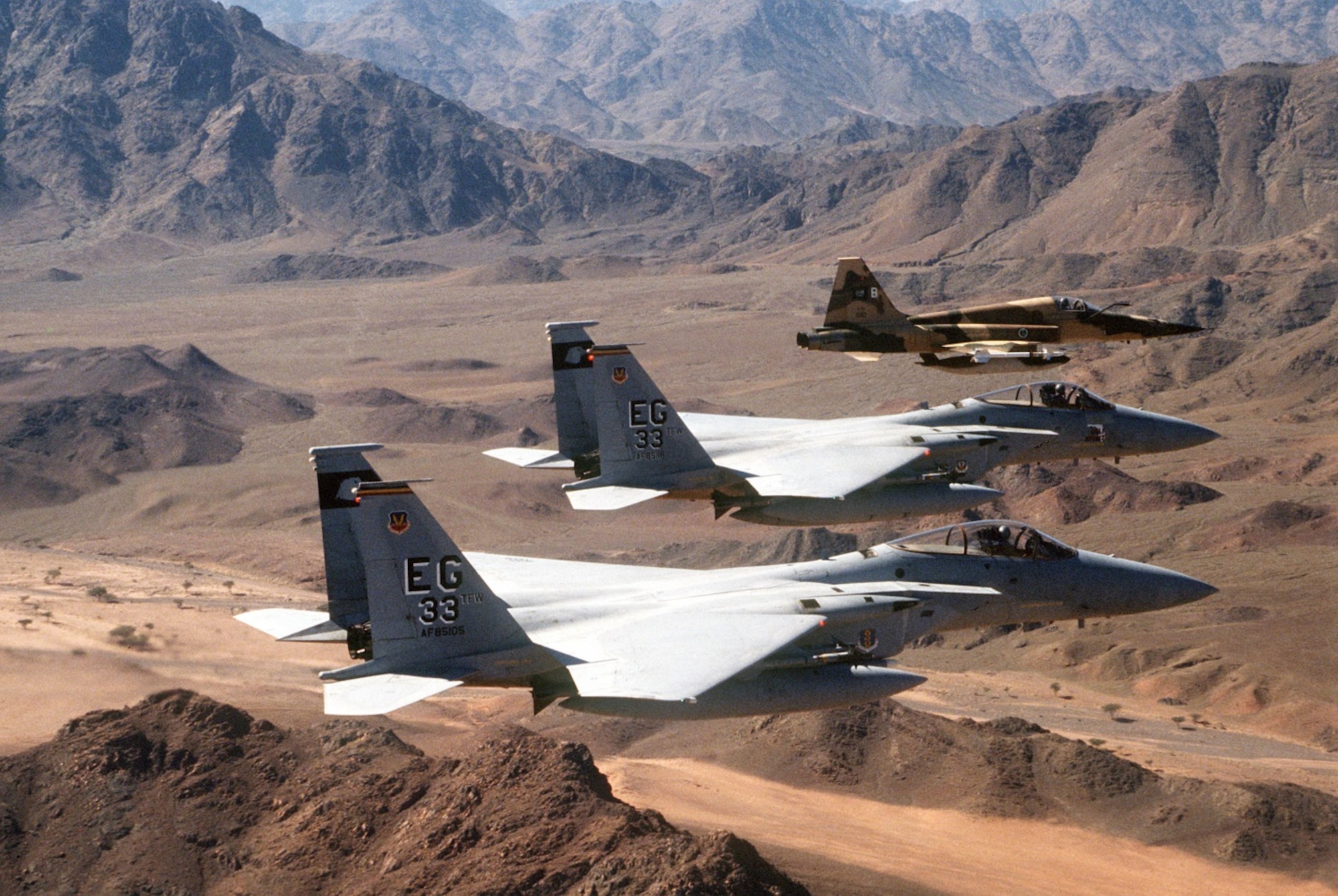 F-15C Eagles fly over Kuwait during the Gulf War in 1991. The Nomads’ participation in Operation Desert Shield began in August 1990 with a total 769 personnel and 24 F-15Cs departing Eglin Air Force Base destined for King Faisal Air Base in northwestern Saudi Arabia. (U.S. Air Force file photos)