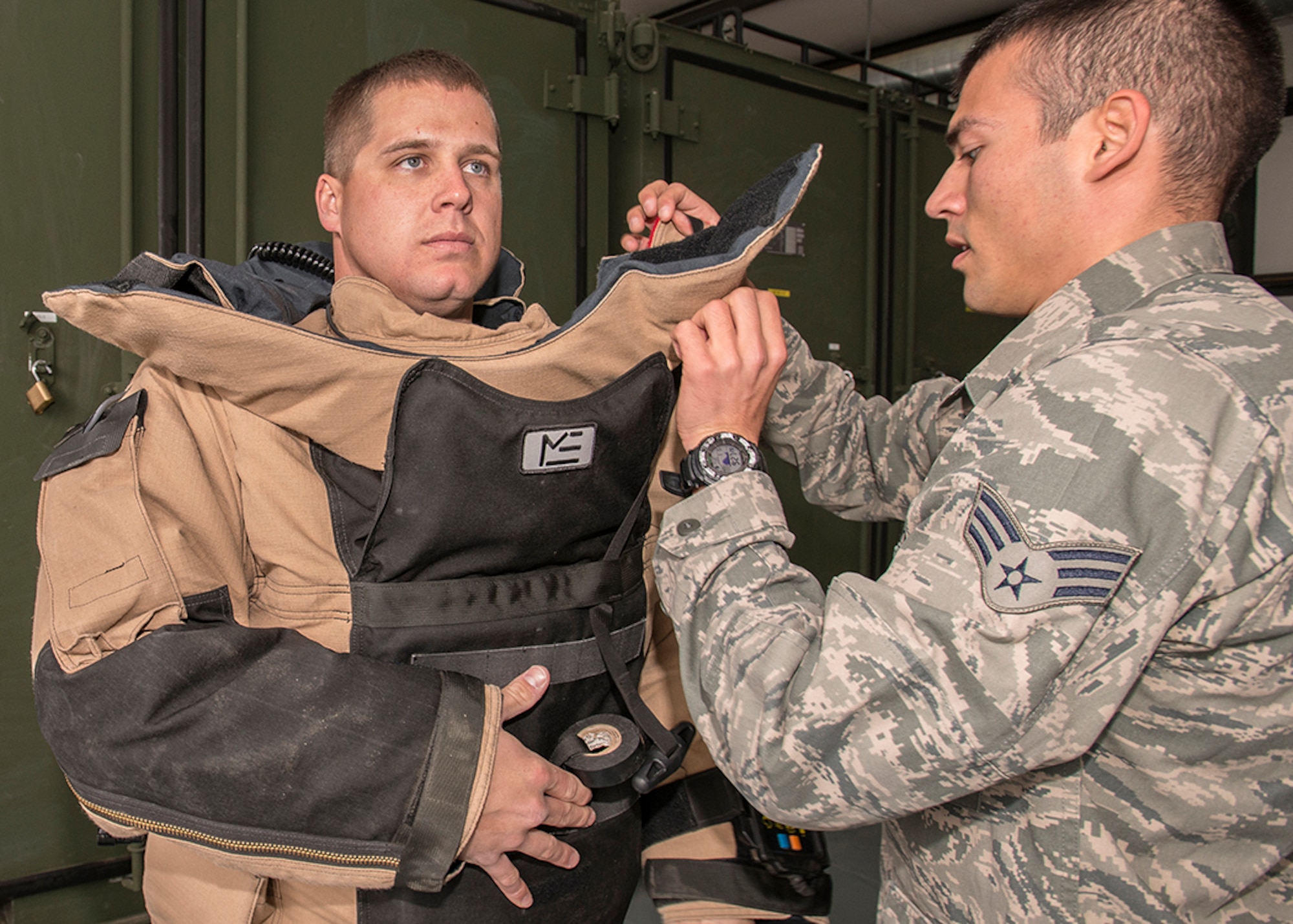 Staff Sgt. Jacob Cumbo, 812th Civil Engineering Squadron, Explosive Ordnance Disposal, is assisted with donning a bomb suit. (U.S. Air Force photo by Edward Cannon)
