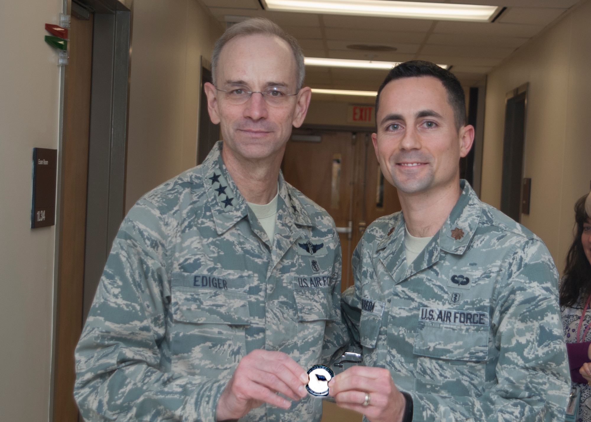 Lt. Gen. Mark Ediger, the Air Force Surgeon General, coins Maj. (Dr.) David Bereda, the Family Health Element Leader, during his visit to the Wright-Patterson AFB Medical Center on Jan. 16. (US Air Force Photo / Mark Pugel)