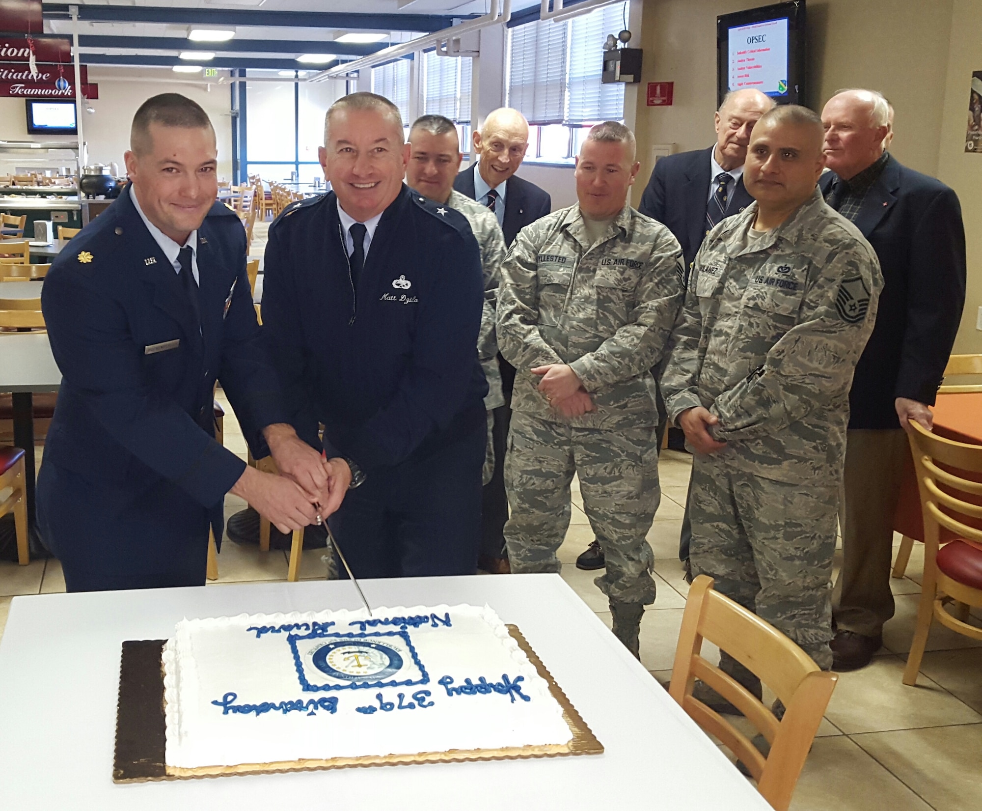 Major Jeremiah Buckenberger, 143d Civil Engineering Squadron Commander and Brigadier General Matthew Dzialo ceremonially cut the cake celebrating the 379th Birthday of the National Guard during a ceremony at Quonset Air National Guard Base, North Kingstown, Rhode Island on December 5, 2015. Photo by Master Sgt Janeen Miller