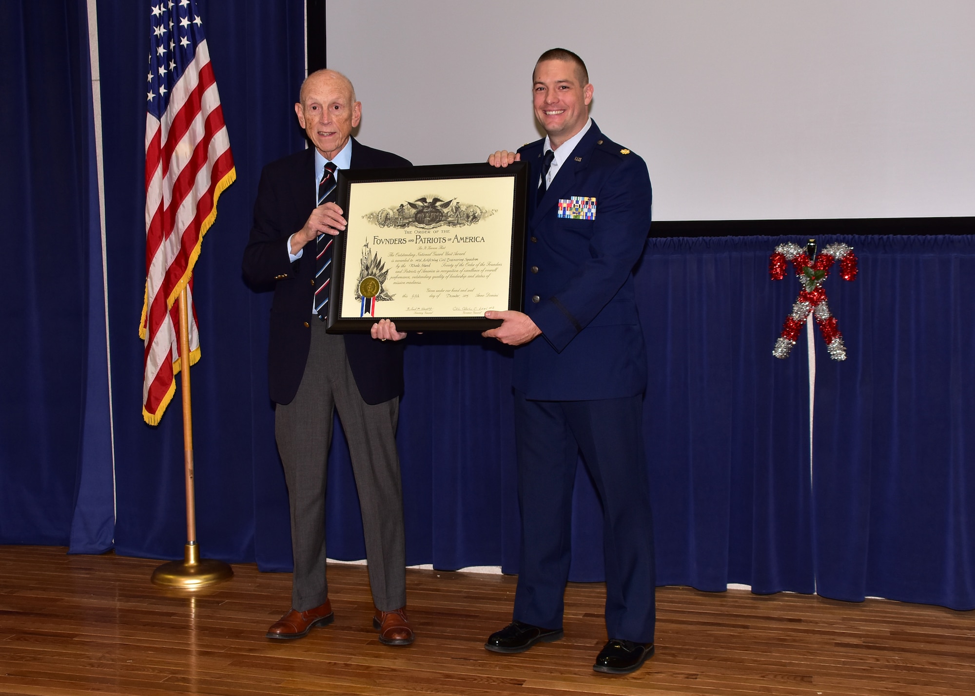 Mr. Robert Baxter of the Rhode Island Society of the Founders and Patriots and Major Jeremiah Buckenberger display the Founders and Patriots award plaque during a ceremony at Quonset Air National Guard Base, North Kingstown, Rhode Island on December 5, 2015. Photo by Tech Sgt Jason Long