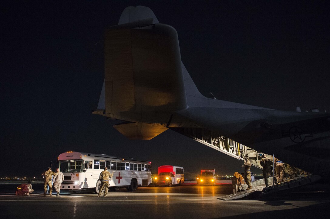U.S. airmen unload patients from a C-130H Hercules aircraft while supporting Operation Inherent Resolve on Al Udeid Air Base in Qatar, Jan. 6, 2016. U.S. Air Force photo by Tech. Sgt. Nathan Lipscomb