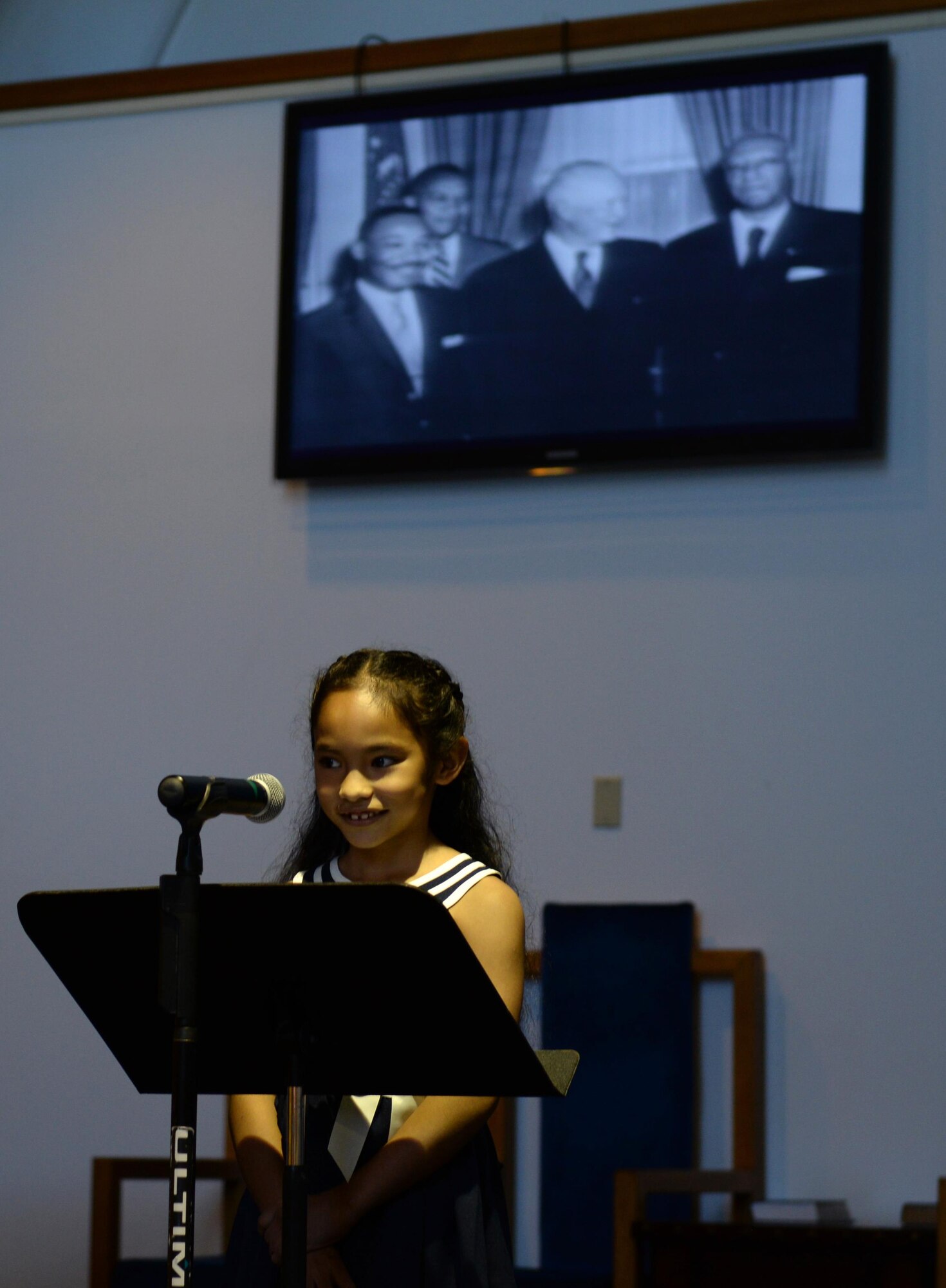 An Andersen Elementary School student reads an essay at the Martin Luther King Jr. Remembrance Ceremony Jan. 14, 2016 at Andersen Air Force Base, Guam. Her essay, about what Martin Luther King Jr. day means to her, was handpicked from all of the submissions turned in by Andersen Elementary students. (U.S. Air Force photo/Airman 1st Class Jacob Skovo)