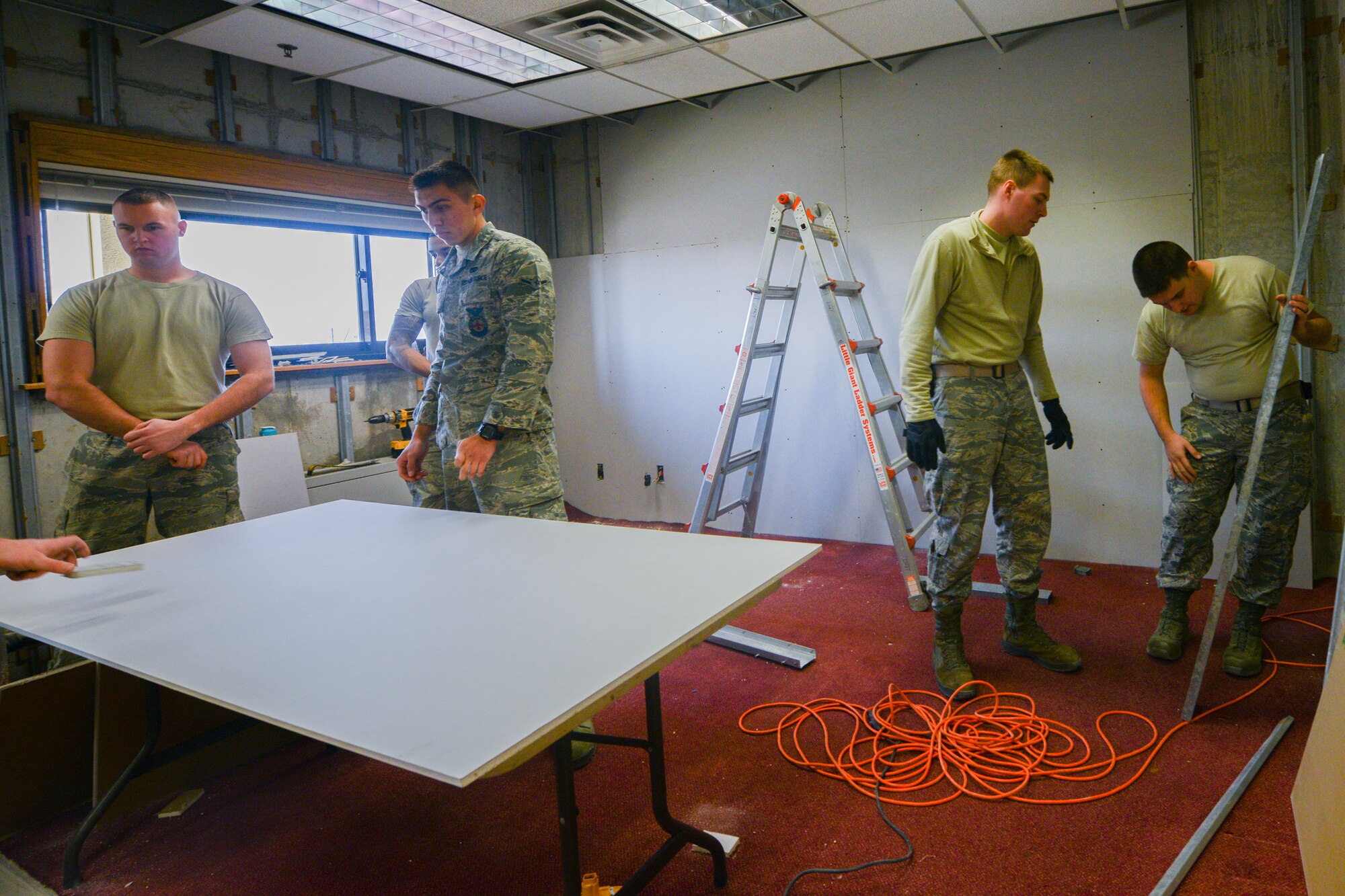 Senior Airman Paul Smith, 51st Civil Engineer Squadron firefighter, places drywall during construction at Osan Air Base, Republic of Korea, Jan. 14, 2016. The 51st CES firefighters renovated a catch-all workstation for its fire-prevention Airmen. The fire-prevention office inspects buildings to prevent future fire mishaps ensuring the safety of the base. (U.S. Air Force photo by Airman 1st Class Dillian Bamman/Released)