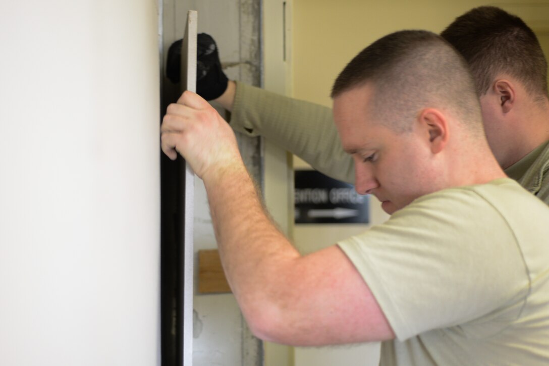 Senior Airman Paul Smith, 51st Civil Engineer Squadron firefighter, cuts a piece of drywall during construction at Osan Air Base, Republic of Korea, Jan. 14, 2016. Smith and other firefighters renovated the building to produce a uniform workcenter for their fire-prevention team. (U.S. Air Force photo by Airman 1st Class Dillian Bamman/Released)