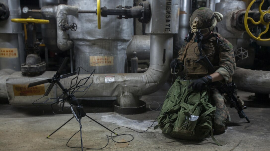 Staff Sgt. Travis Caron sets up satellite communications during a raid Jan. 13, 2015, as part of Realistic Urban Training Exercise on Guam. RUTEX is a high-intensity close-quarter battle training exercise conducted in an actual urban environment to provide a high degree of realism to the training. The exercise is part of the Maritime Raid Force’s pre-deployment training before their upcoming deployment with the 31st MEU. Caron, from Sneads Ferry, North Carolina, is the Force Reconnaissance Platoon communications chief with MRF, 31st MEU.