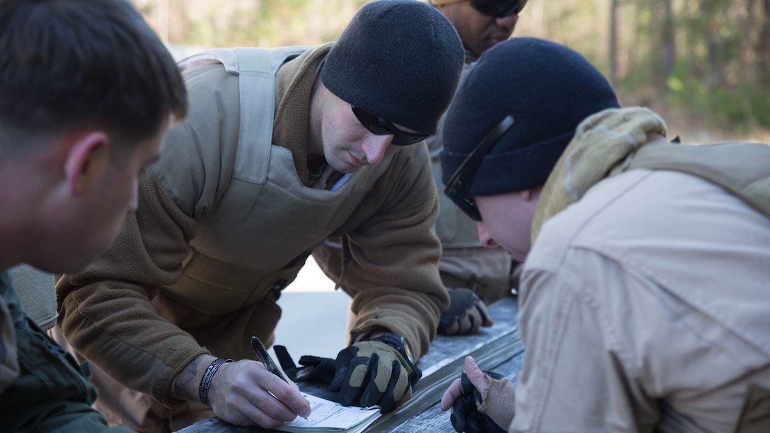 Explosive Ordinance Disposal technicians with EOD Company, 8th Engineer Support Battalion, review their calculations to build the correct sized explosive during a breaching course at Camp Lejeune, N.C., Jan. 14, 2016. The Marines were tasked to build their own explosives for the raids. 
