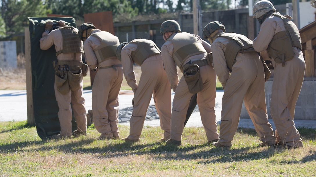 Explosive Ordinance Disposal technicians with EOD Company, 8th Engineer Support Battalion, practice “stacking-up” during a breaching course at Camp Lejeune, N.C., Jan. 14, 2016. The Marines take cover behind a shielding blanket and one another to reduce the chances of being struck by debris. 