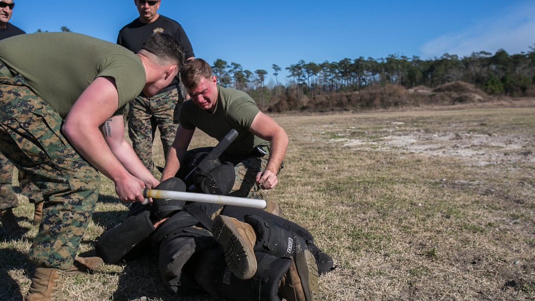 Lance Cpl. Hunter Rooks, left, and Lance Cpl. Joshua Sutton, both Marines with Combat Logistics Battalion 22, perform a two-man takedown against an armed aggressor after being sprayed in the eyes with oleoresin capsicum, more commonly known as OC spray, at Camp Lejeune, N.C., Jan. 14. The take-down was part of an obstacle course, which also entailed the use of other baton techniques, blocking attacks from an assailant and a two-man takedown against an armed aggressor. 
