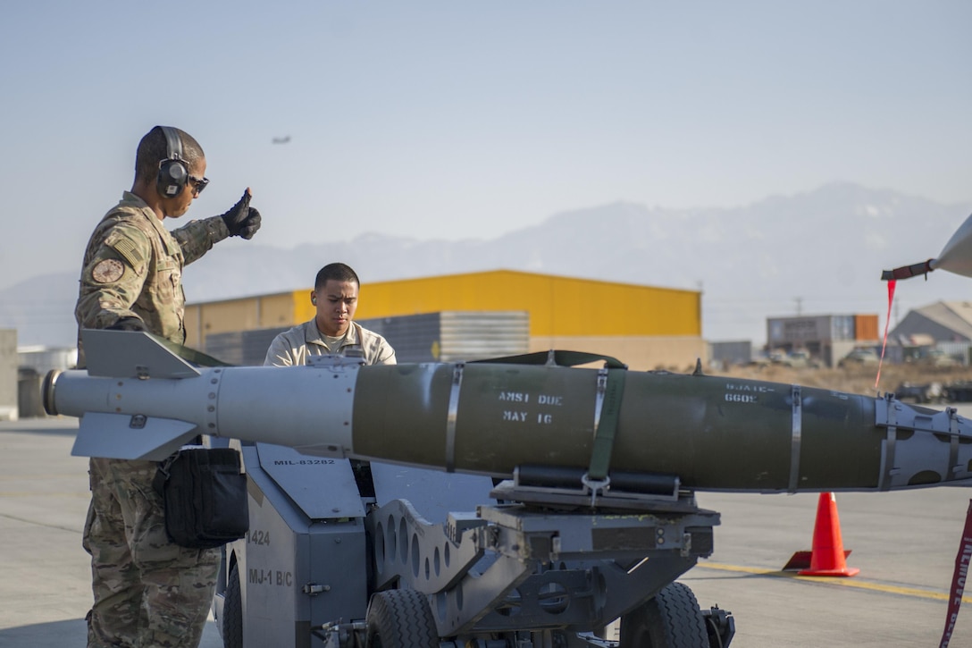 Air Force Staff Sgt. Chris White, left, directs Air Force Airman 1st Class Rhaymark Neri as he moves a GBU-54 to a bomb stand on Bagram Airfield, Afghanistan, Jan. 15, 2016. White and Neri are weapons load crew members assigned to the 455th Expeditionary Aircraft Maintenance Squadron. U.S. Air Force photo by Tech. Sgt. Robert Cloys