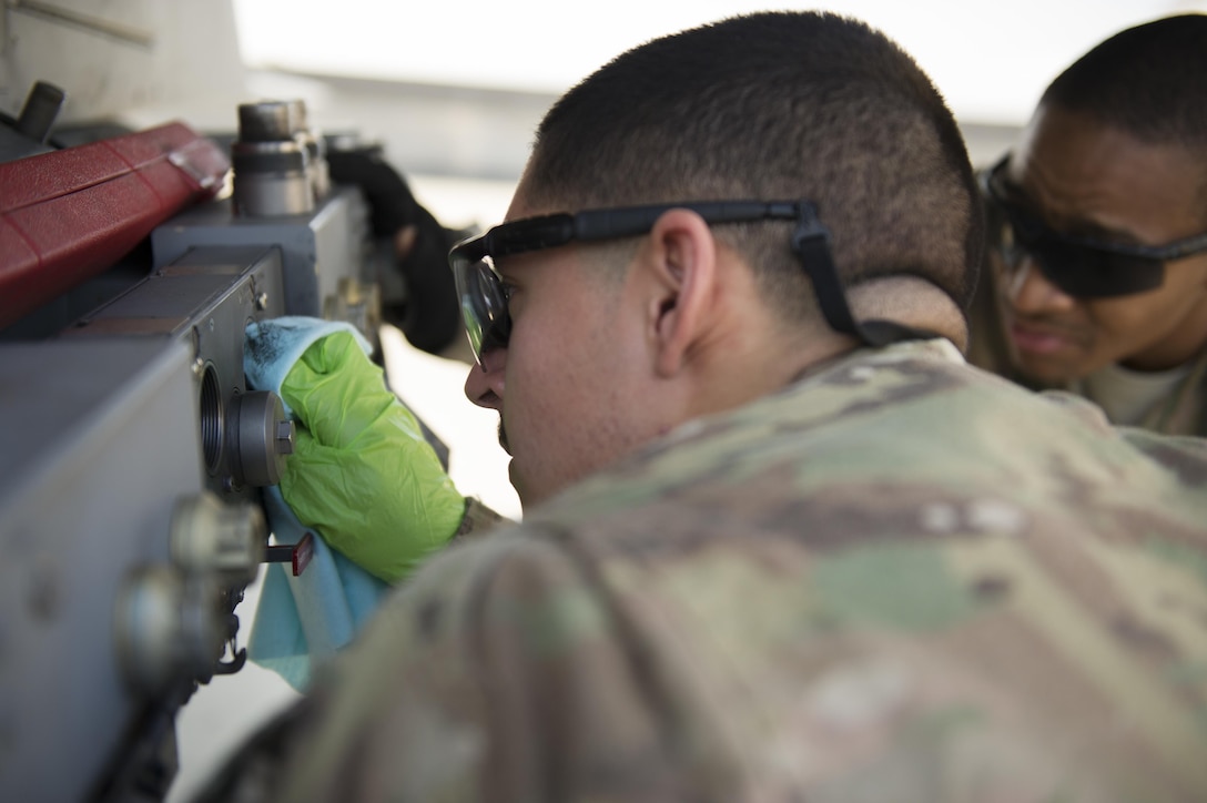 Air Force Airman 1st Class Gabriel Rey, foreground, lubricates a BRU-57 on an F-16 Fighting Falcon aircraft during a 30-day inspection on Bagram Airfield, Afghanistan, Jan. 15, 2016. U.S. Air Force photo by Tech. Sgt. Robert Cloys