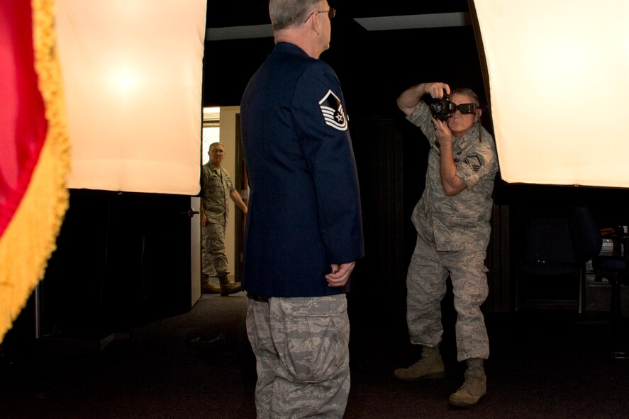 U.S. Air Force Reserve Master Sgt. Jeff Walston, a public affairs technician assigned to the 913th Airlift Group, seems to catch a glimpse of himself photographing himself taking an official photo of himself, at Little Rock Air Force Base, Ark. Walston is training to use the photo studio equipment at the 19th Airlift Wing Public Affairs office so Reserve Airmen can have official photos taken during the monthly Unit Training Assembly weekends. (U.S. Air Force photo illustration by Master Sgt. Jeff Walston/Released)    