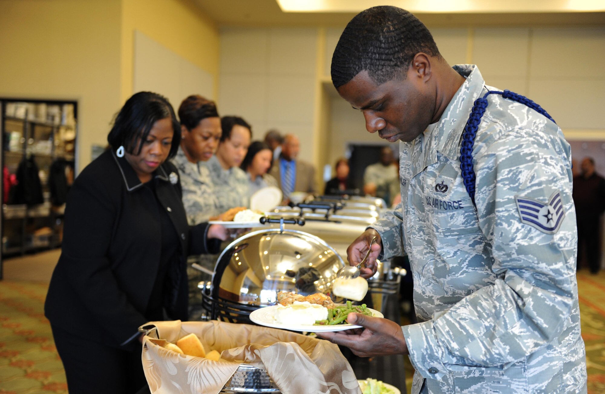 Staff Sgt. L.C. Fowler, 338th Training Squadron military training leader, joins the buffet line at the annual Dr. Martin Luther King Jr. Memorial Luncheon at the Bay Breeze Event Center, Jan. 14, 2016, Keesler Air Force Base, Miss. The event was held to honor the legacy of King who inspired civil rights activism within the African American community. The Keesler African-American Heritage Committee sponsored the event. (U.S. Air Force photo by Kemberly Groue)